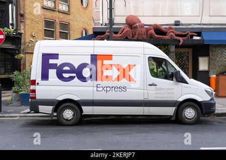 Camionnette FedEx livrant un colis à Londres, Royaume-Uni. Concept: Services de messagerie, livraison de colis, service de courrier express, commande en ligne Banque D'Images