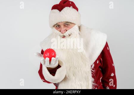 Nouvelle année et concept de méchant. Le Père Noël tient un virus dans ses mains et sourit de manière vicieuse. Banque D'Images