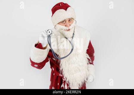 Concept vacances et Noël. Le Père Noël tient un stéthoscope dans sa main. Isolé sur blanc Banque D'Images