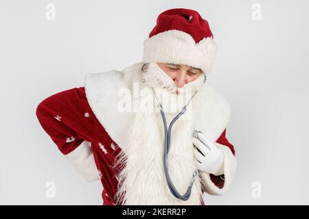 Concept vacances et Noël. Le Père Noël tient un stéthoscope dans sa main - écoute son cœur. Isolé sur blanc Banque D'Images