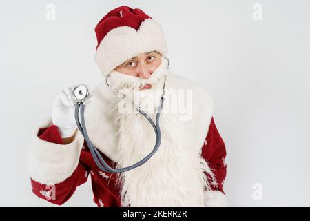 Concept vacances et Noël. Le Père Noël tient un stéthoscope dans sa main. Isolé sur blanc Banque D'Images
