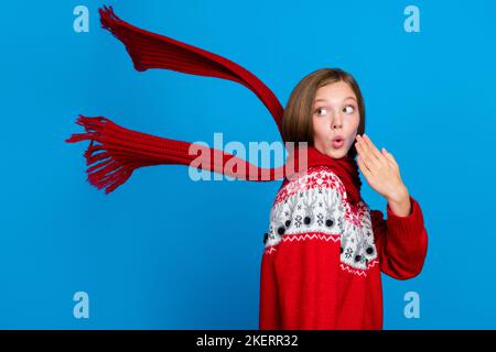 Photo de rêve impressionné école fille porter rouge Noël ornement chandail regardant arrière vide espace isolé bleu couleur fond Banque D'Images