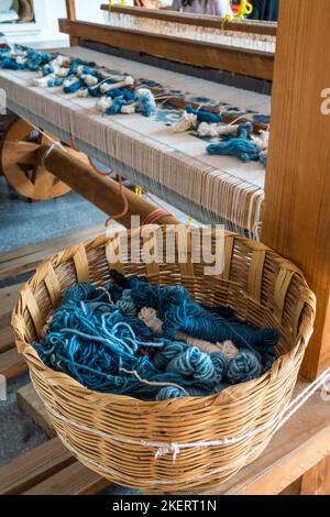 Fils de laine à utiliser pour le tissage de tapis à Teotitlan del Valle, un célèbre centre de tissage près d'Oaxaca, au Mexique. Derrière se trouve un tapis tissé sur un lo en bois Banque D'Images