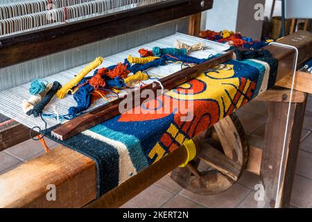 Tapis de laine fabriqués avec des teintures naturelles étant tissés sur des métiers à pied en bois dans une boutique de tissage familiale à Teotitlan del Valle, Oaxaca, Mexique. Banque D'Images