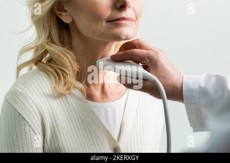 vue rognée de la femme adulte près d'un médecin effectuant un examen échographique de son larynx, image de stock Banque D'Images