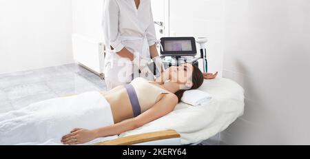 Femme ayant une procédure de levage RF pour serrer la peau de ses mains et de son corps avec une esthéticienne au centre de cosmétologie. Levage RF Banque D'Images