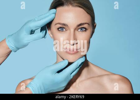 Forme idéale de visage de femme pour chirurgien plastique, référence visage de femme sur fond bleu. Chirurgie plastique, concept Banque D'Images