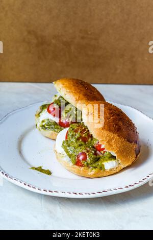 Sandwiches italiens Caprese avec tomates cerises fraîches, fromage mozzarella et sauce pesto. Prêts à manger. Banque D'Images