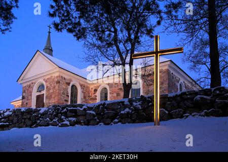 Croix illuminée en face de l'église Uskela, construite en 1832 et conçue par le célèbre architecte finlandais C. L. Engel, au crépuscule du jour de Noël. Salo, fin Banque D'Images