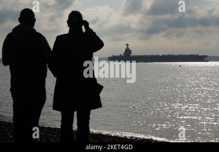 Les gens regardent l'USS Gerald R. Ford qui se rend dans Stokes Bay, dans le Solent, alors que le « plus grand navire de guerre du monde » passera quatre jours à s'ancrer au large de la côte du Hampshire lors de son premier déploiement. Date de la photo: Lundi 14 novembre 2022. Banque D'Images