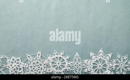 Produits de Noël ou d'hiver fond, bleu brut artisanat papier bord inférieur décoré avec des flocons de neige crochet faits à la main, beaucoup d'espace de copie. Banque D'Images