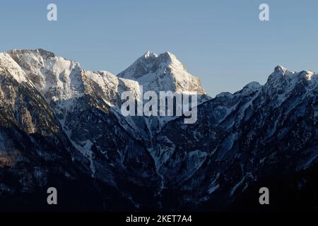 Vue imprenable sur un pic de montagne au coucher du soleil. Sommet d'accès difficile pour les grimpeurs. Alpinisme et grimpeurs. Ciel bleu et couleurs vives. Banque D'Images