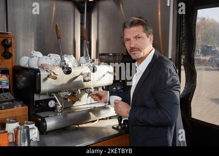 14 novembre 2022, Basse-Saxe, Lüneburg: Acteur Hardy Krüger Jr. AS Ralf, se tient dans un kiosque mobile de café lors d'une séance photo pour la saison 21st de la série télévisée 'Rote Rosen. Photo: Georg Wendt/dpa Banque D'Images