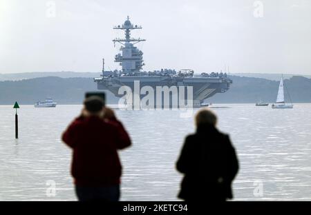 Les gens regardent l'USS Gerald R. Ford lorsqu'ils sont à l'ancre dans Stokes Bay, dans le Solent, alors que le « plus grand navire de guerre du monde » passera quatre jours à s'ancrer au large de la côte du Hampshire pendant son déploiement inaugural. Date de la photo: Lundi 14 novembre 2022. Banque D'Images