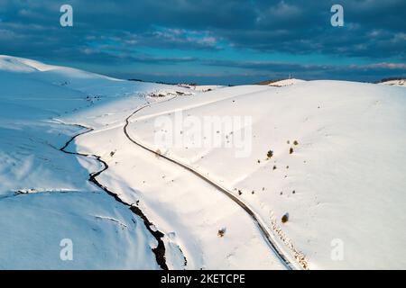 Photo aérienne de la route vide et du ruisseau de montagne gelé en paysage hivernal à Zlatibor, Serbie Banque D'Images