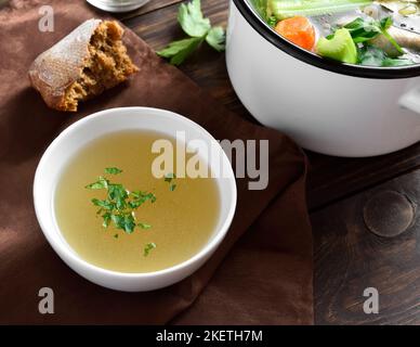 Bouillon de poulet avec légumes et épices sur table en bois. Banque D'Images