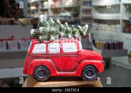 Voiture-jouet enneigée avec un arbre de Noël sur fond de bokeh. Concept de Noël Banque D'Images