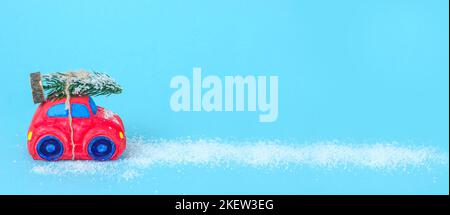 Bannière bleue avec voiture rouge et arbre de noël recouvert de neige avec espace de copie. Banque D'Images