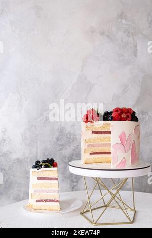 gâteau rose décoré de chocolat blanc fondu, macarons Banque D'Images