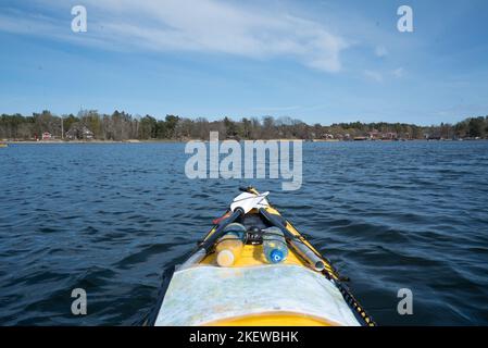 La vue à bord d'un kayak de mer jaune, pagayant à travers les îles de l'archipel suédois de Stockholm, en Suède. Banque D'Images