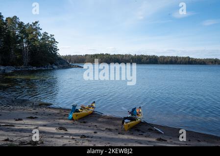 Deux kayaks de mer jaunes se sont tirés sur une plage de sable sur une île de l'archipel de Stockholm, en Suède. Kayak dans l'archipel suédois, mer Baltique. Banque D'Images