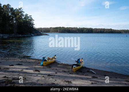 Deux kayaks de mer jaunes se sont tirés sur une plage de sable sur une île de l'archipel de Stockholm, en Suède. Kayak dans l'archipel suédois, mer Baltique. Banque D'Images