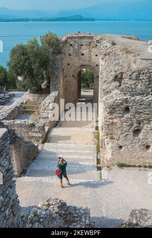 Sirmione Grotte di Catullo, vue d'un touriste photographiant les ruines d'une ancienne villa romaine que l'on croyait être la maison de Catullus, lac de Garde Italie Banque D'Images