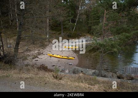 Paire de kayaks de mer jaunes sur une plage sur une île de l'archipel de Stockholm, en Suède. Kayak dans l'archipel suédois, mer Baltique. Banque D'Images