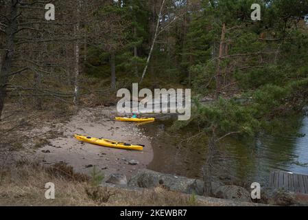 Paire de kayaks de mer jaunes sur une plage sur une île de l'archipel de Stockholm, en Suède. Kayak dans l'archipel suédois, mer Baltique. Banque D'Images