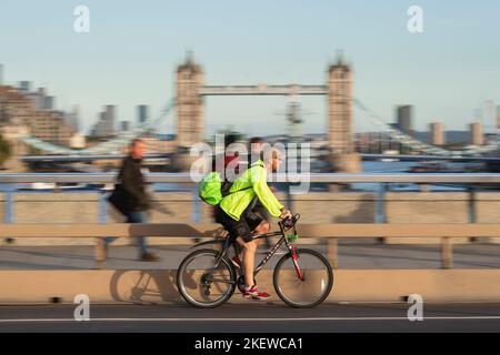 Un homme qui fait du vélo pendant les heures de pointe, traverse le London Bridge, Londres, Royaume-Uni. 18 octobre 2022 Banque D'Images