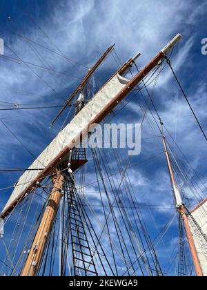 Le mât du bateau à voile traverse le ciel. Banque D'Images