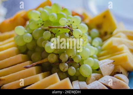 Raisin, fromage et fruits. Concept de saine alimentation. Assiette de raisin mûr, fromage, banane et ananas. Vitamines sur plaque. Plats végétariens. Fruits doux Banque D'Images