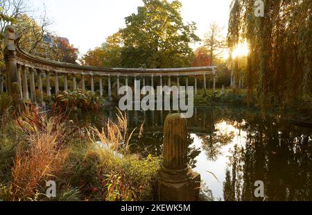 Les anciennes colonnes du Parc Monceau se reflètent dans l'eau du bassin ovale, au soleil . Ce jardin public est situé dans le 8th arrondissement Banque D'Images