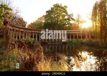 Les anciennes colonnes du Parc Monceau se reflètent dans l'eau du bassin ovale, au soleil . Ce jardin public est situé dans le 8th arrondissement Banque D'Images