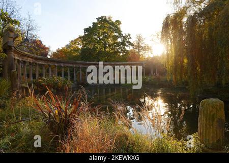 Les anciennes colonnes du Parc Monceau se reflètent dans l'eau du bassin ovale, au soleil . Ce jardin public est situé dans le 8th arrondissement Banque D'Images