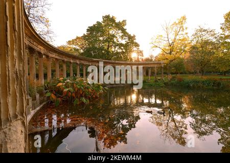 Les anciennes colonnes du Parc Monceau se reflètent dans l'eau du bassin ovale, au soleil . Ce jardin public est situé dans le 8th arrondissement Banque D'Images