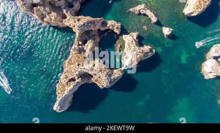 Tir de drone aérien de kayaks et de bateaux passant autour des falaises calcaires magiques de Ponta da Piedade. Exploration des grottes et des tunnels de Lagos Algarve Portugal Banque D'Images