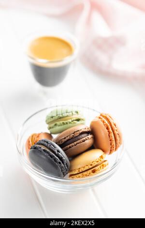 Dessert au macaron sucré. Macarons colorés dans un bol sur la table blanche. Banque D'Images