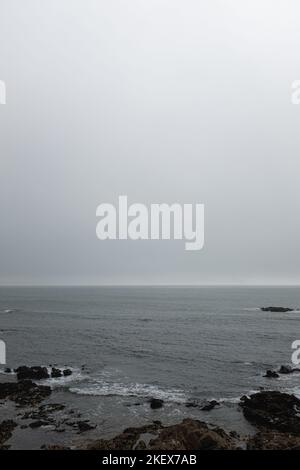 Prévisions de brouillard gris pluvieux sur un paysage de mer rocailleux Banque D'Images