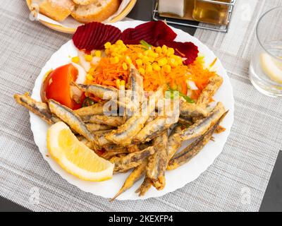 Frits dans des anchois de pâte à frire avec des légumes frais et du citron Banque D'Images