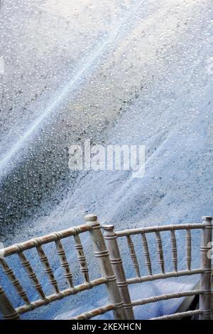 chaises dans un chapiteau de mariage avec pluie à l'extérieur Banque D'Images