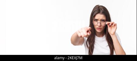 Gros plan portrait d'une femme suspecte, judgmentale dans des lunettes, blâmer quelqu'un, frognant, se calant sur la personne qu'elle blâme, pointant des accusations de doigt Banque D'Images