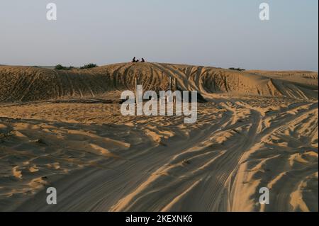 Marques de pneus de voiture sur les dunes de sable du désert de Thar, Rajasthan, Inde. Les touristes arrivent sur des voitures pour regarder le soleil se lever dans le désert , une activité touristique très populaire . Banque D'Images