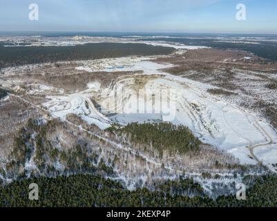 Vue aérienne de la carrière de pierre concassée en hiver avec de la neige. Exploitation de la pierre concassée en hiver. Banque D'Images