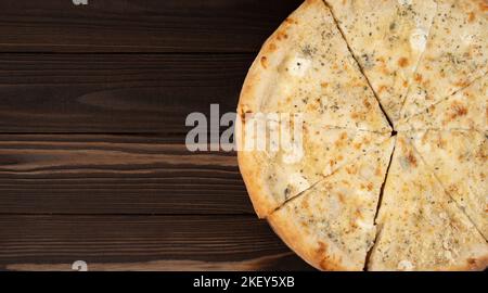 Pizza délicieuse quatre fromages avec cheddar, parmesan, mozzarella et sauce tomate. Sur fond de bois. Vue de dessus. Banque D'Images