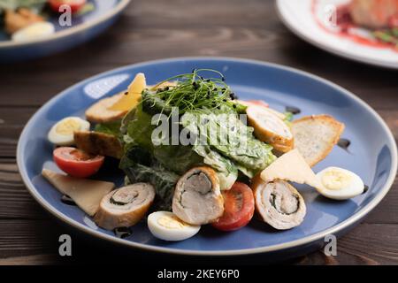 Salade césar gastronomique avec rouleau de poulet grillé sur l'assiette Banque D'Images