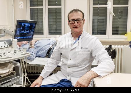 Hambourg, Allemagne. 11th novembre 2022. Frank Sommer, urologue, andrologue et professeur de santé masculine, est assis dans une salle d'examen avant d'examiner un patient. (À dpa: 'Cliquez plus souvent, allez au médecin moins souvent - faire plus pour la santé des hommes") Credit: Markus Scholz/dpa - ATTENTION: Les tatouages et le nom du patient sur l'écran ont été pixelated pour des raisons juridiques/dpa/Alamy Live News Banque D'Images