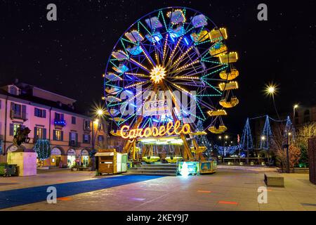 Grande roue illuminée sous le ciel avec des étoiles sur la place de la ville pendant les célébrations de Noël à Alba, Italie. Banque D'Images