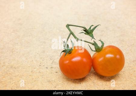 Deux tomates cerises rouges sur fond de bois Banque D'Images