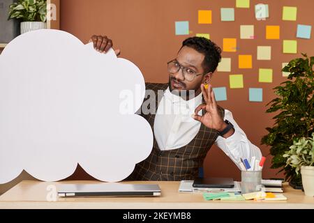 Un chef de projet enthousiaste montrant le nuage de papier et l'affiche « Making ok » Banque D'Images